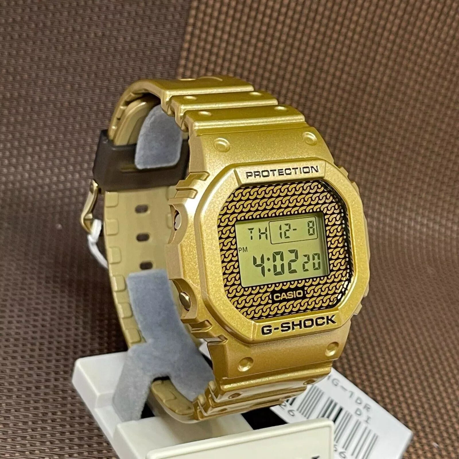 Casio G-Shock DWE-5600HG-1D Orologio con cinturino e lunetta con design a catena d'oro